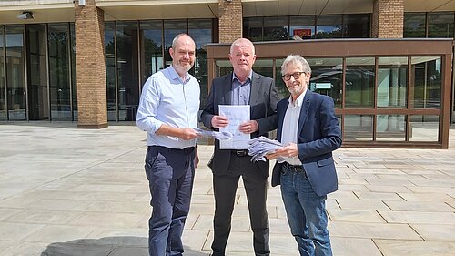 Dan Roper and Steve Riley hand over the petition