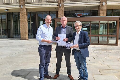 Dan Roper and Steve Riley hand over the petition